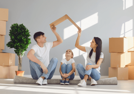 Family planning their new home while sitting on the floor with an empty picture frame.